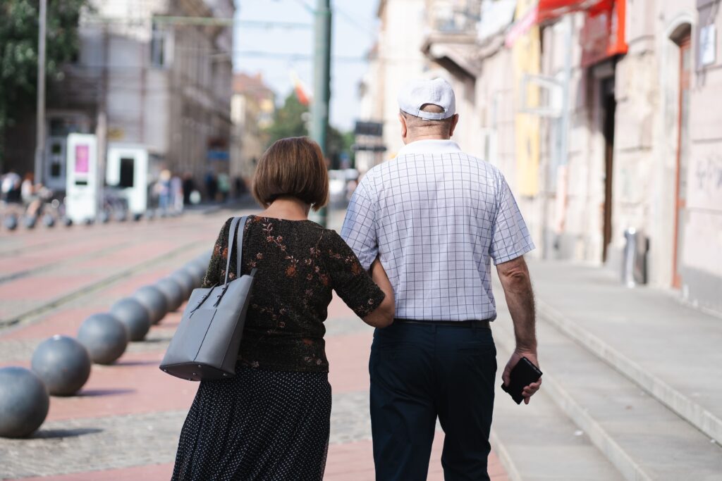 Pareja de adultos mayores caminando tomados del brazo